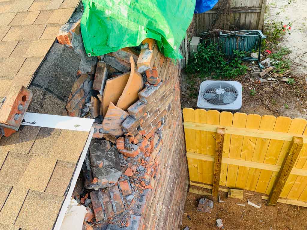 A chimney sweep came out and fixed the side of someone's house with a damaged chimney