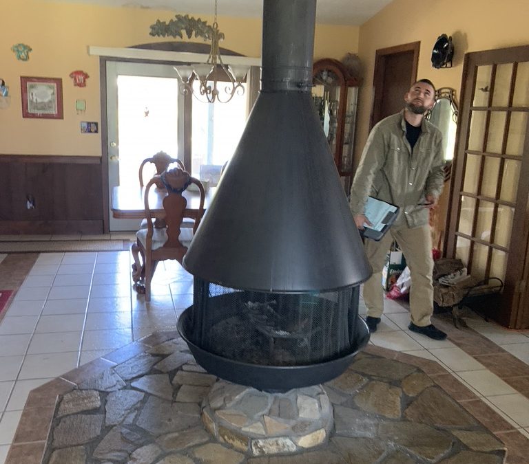 Our tech seeing if there is water damage at the roof where the chimney comes through