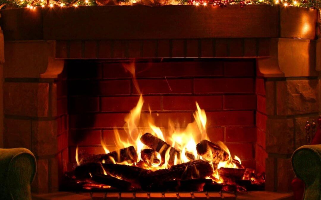 a lit fireplace around christmas time